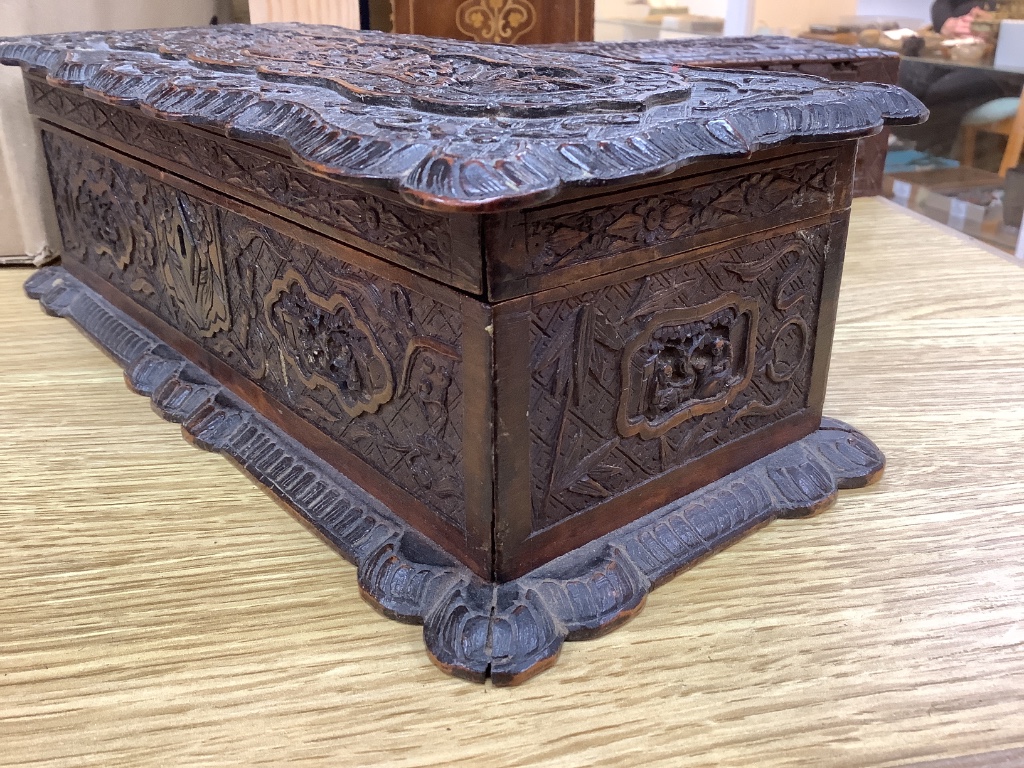 Two 19th century Chinese carved sandalwood boxes, together with a similar puzzle box, length 27cm